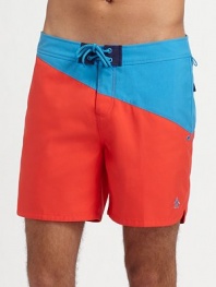 An easy-fitting swim favorite with a colorblocked design of saturated color in quick-dry nylon. Drawstring waist Side slash, back flap pockets Mesh lining Inseam, about 6 Polyester Machine wash Imported 