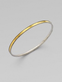 From the Lancelot Collection. Thoroughly modern and thoroughly stunning, this slender bangle of hammered sterling silver is encircled by a gleaming band of 24k gold.Sterling silver and 24k yellow goldDiameter, about 2½Imported